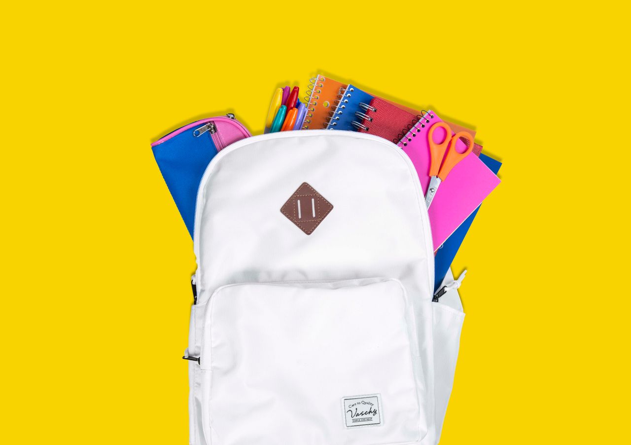 services-02 Colorful school supplies in a white backpack against a vibrant yellow background.