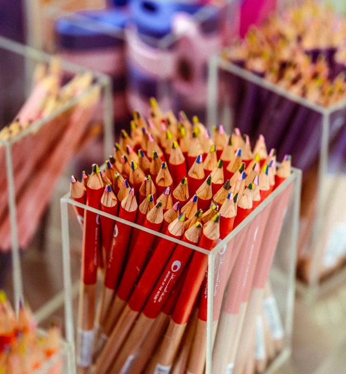 services-10 Vibrant colored pencils neatly arranged in a clear acrylic box on display.