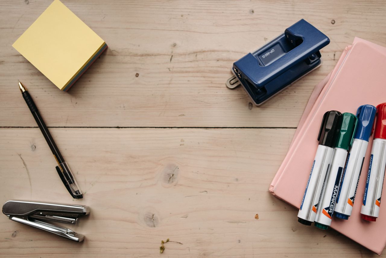 about-03 Flat lay of office supplies on a wooden desk for a neat workspace setup.