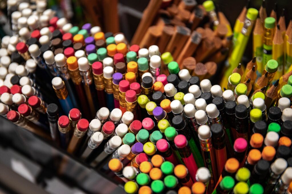 A vibrant collection of pencils with erasers viewed from above, showcasing creativity.